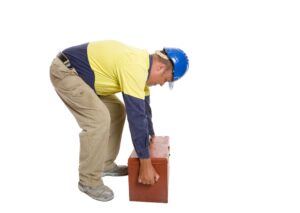 an employee trying to lift a box. 