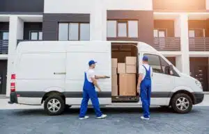Two delivery drivers opening a van. Inside are stacked boxes.