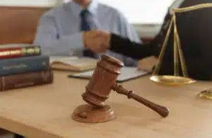 A good personal injury lawyer sitting behind a desk with an open book and a gavel